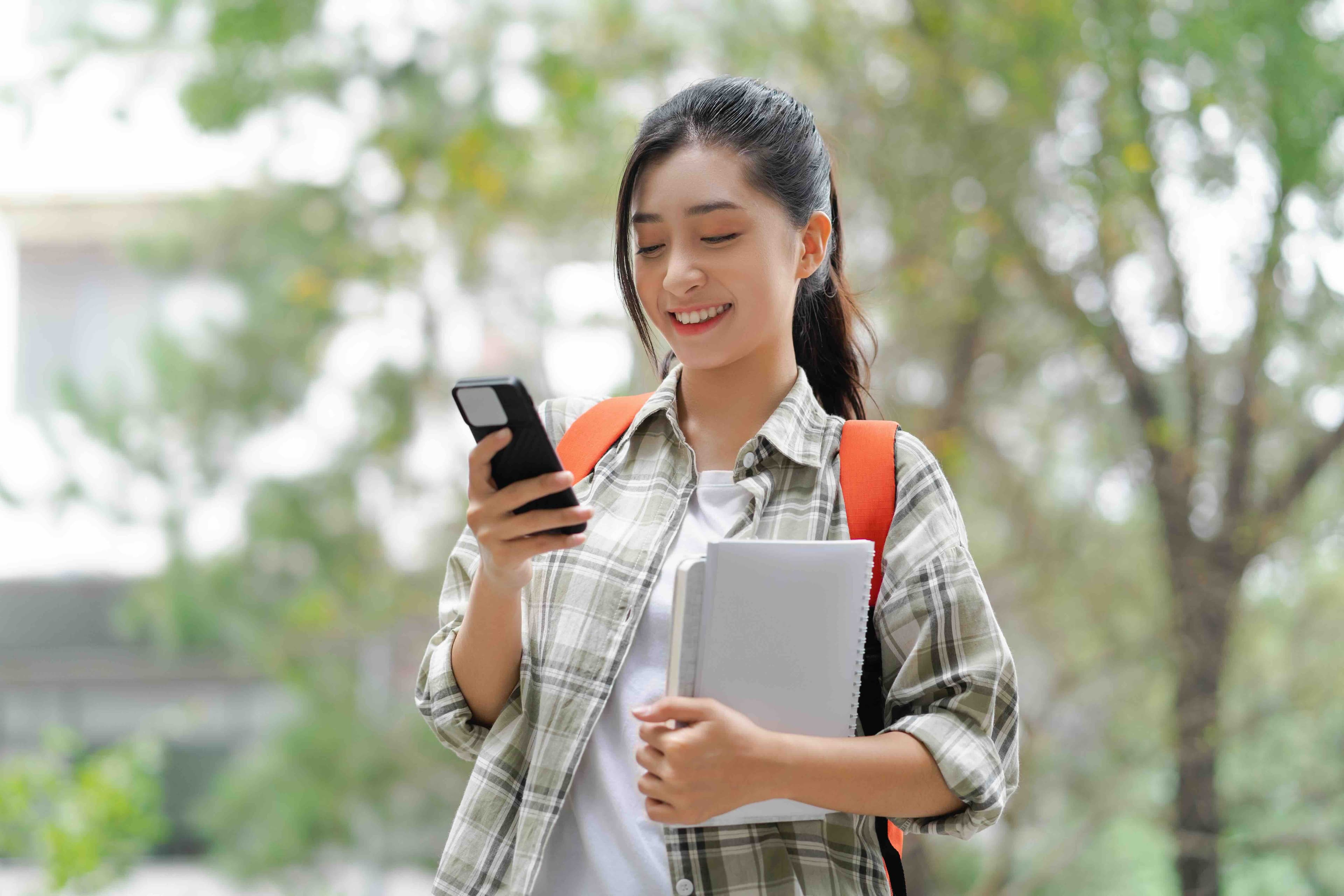 student-texting-on-campus